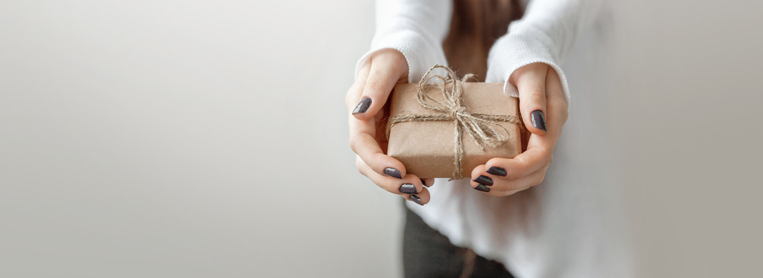 Frau hält umweltfreundlich verpacktes Geschenk