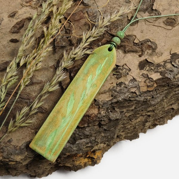 Preview: hand tooled leather pendant with grasses motive on adjustable leather cord
